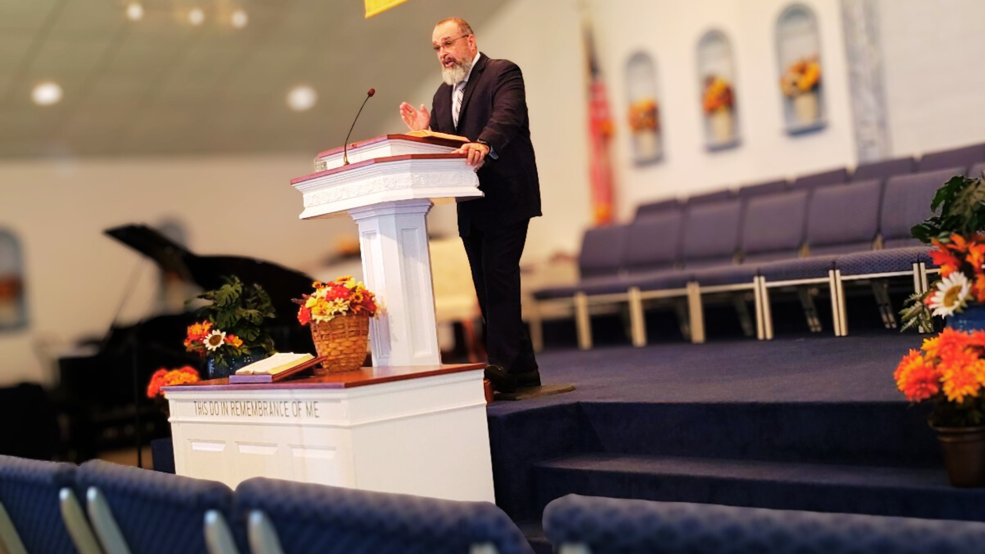 Pastor Tim behind the pulpit preaching